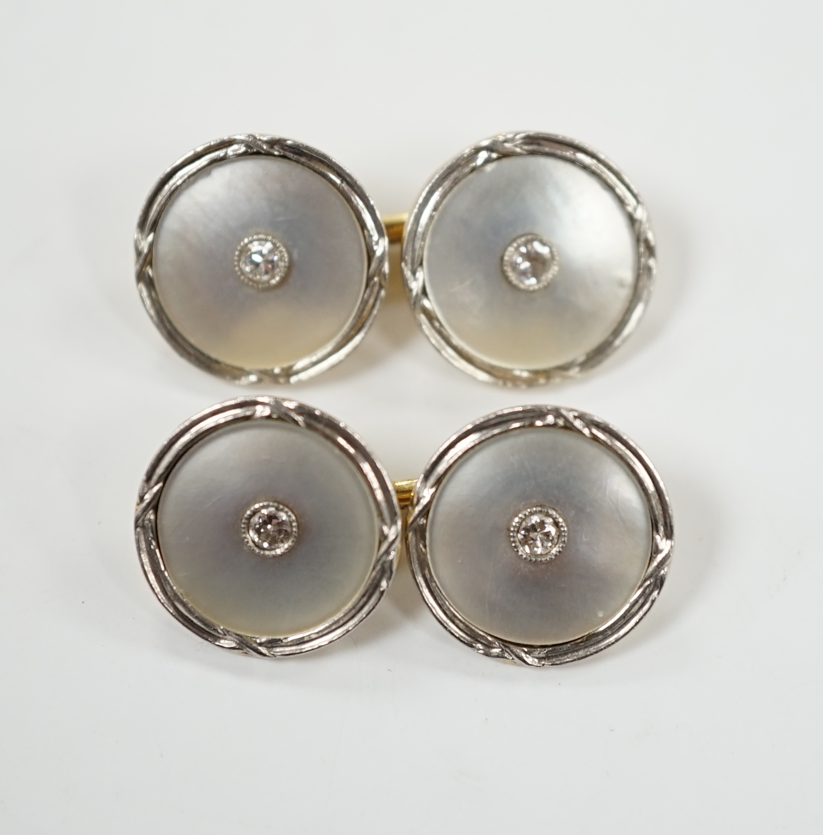 A pair of 14k yellow metal, mother of pearl and diamond chip set circular cufflinks, 12mm, gross weight 6.4 grams.